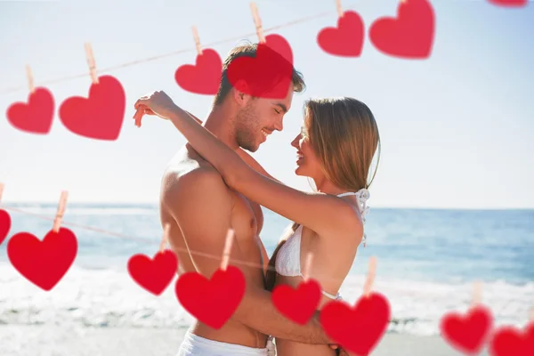 Sexy couple embracing against hearts — Stock Photo, Image