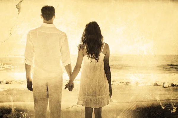 Приваблива пара тримає руки і дивиться океан — стокове фото