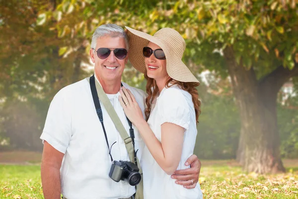 Vacationing couple against trees and meadow — Stock Photo, Image