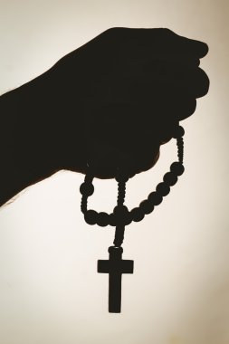 Hand holding rosary beads clipart