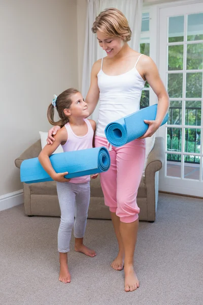 Mother and daughter with yoga mats — Stock Photo, Image