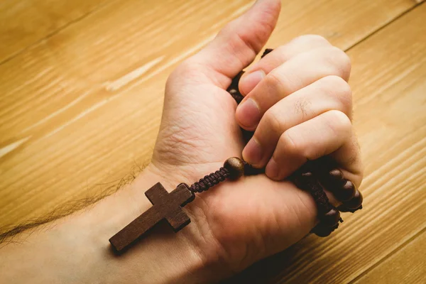 Hand holding wooden rosary beads — Stock Photo, Image