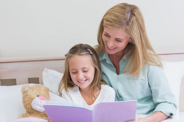 Feliz madre e hija leyendo un libro —  Fotos de Stock