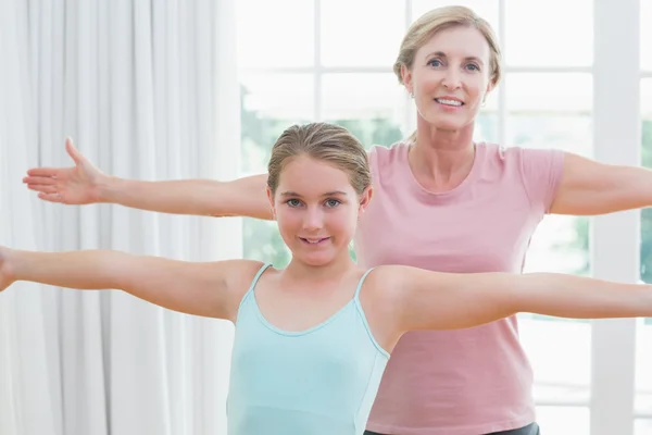Mutlu anne ve kızı yoga yaparken — Stok fotoğraf