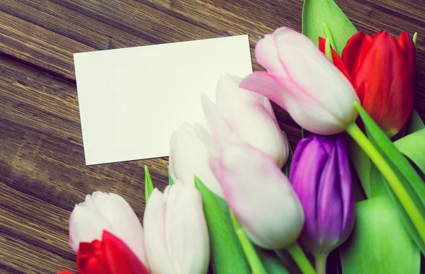 Bunch of tulips and white card — Stock Photo, Image