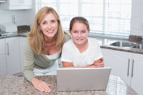 微笑的母亲和女儿在一起使用的笔记本电脑 — 图库照片