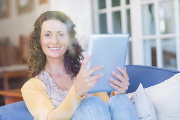 Morena relajante en el sofá con la tableta — Foto de Stock