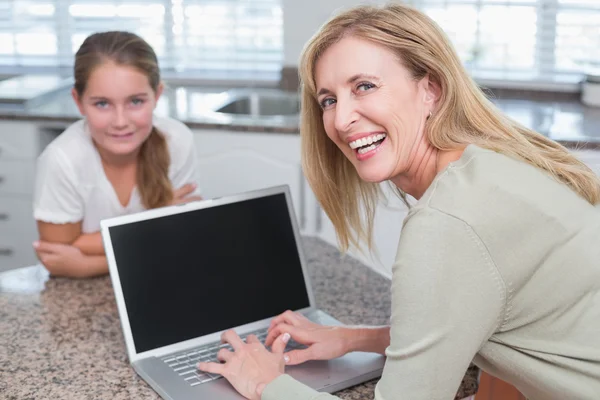 Madre feliz usando el ordenador portátil con su hija — Foto de Stock