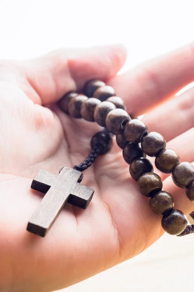 Mano sosteniendo cuentas de rosario de madera — Foto de Stock