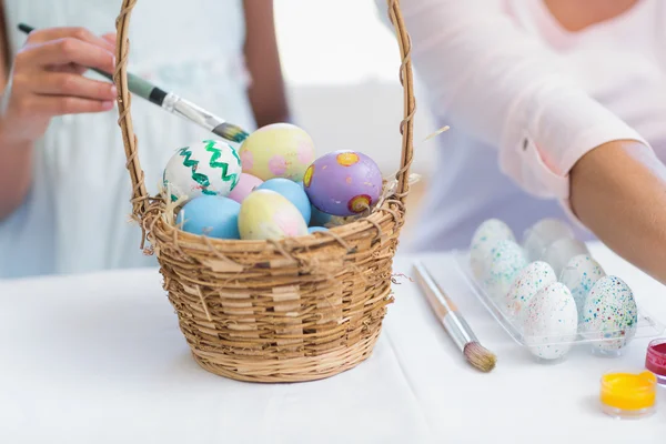 Happy mother and daughter painting easter eggs — Stock Photo, Image