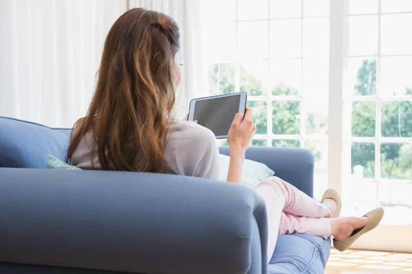 Mujer casual usando la tableta en el sofá — Foto de Stock