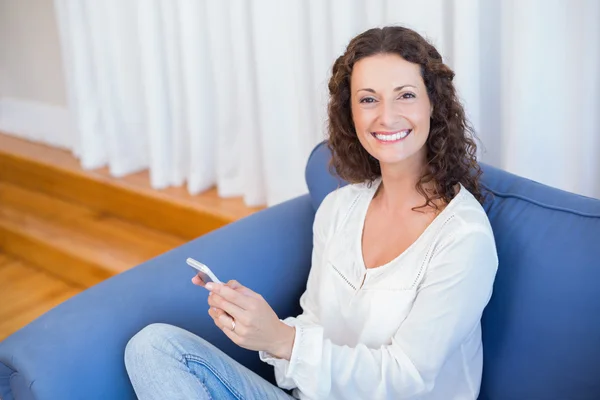 Usmívající se žena pomocí svého mobilního telefonu — Stock fotografie