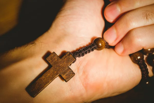 Mano sosteniendo cuentas de rosario de madera — Foto de Stock