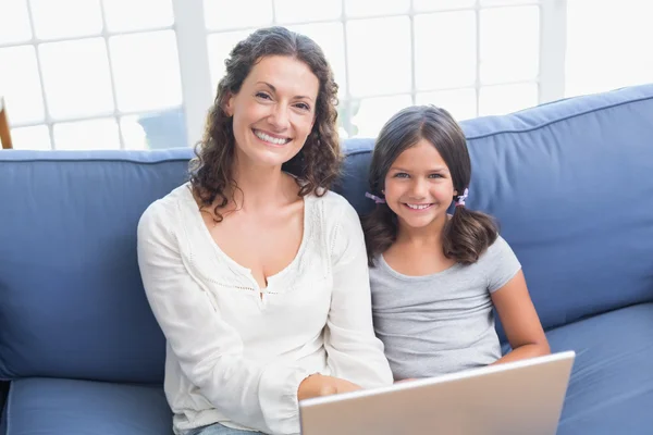 Mãe feliz e filha usando laptop — Fotografia de Stock