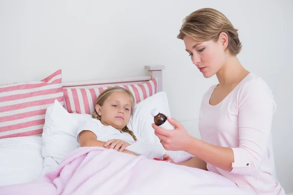 Mother about to give medicine to sick daughter — Stock Photo, Image