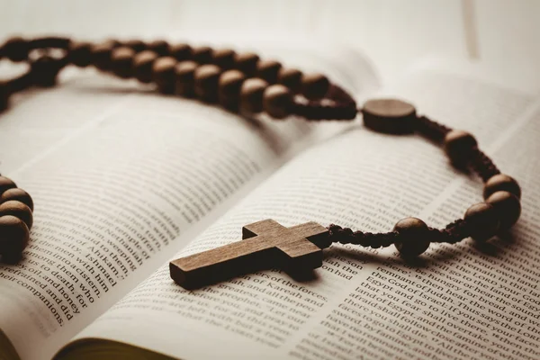Biblia aberta e contas rosário de madeira — Fotografia de Stock