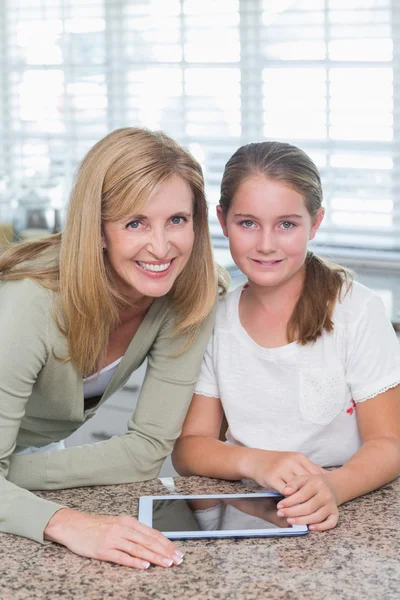 Gelukkig moeder en dochter met behulp van tablet pc samen — Stockfoto