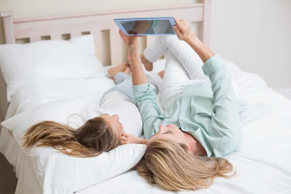 Mãe feliz e filha usando tablet — Fotografia de Stock