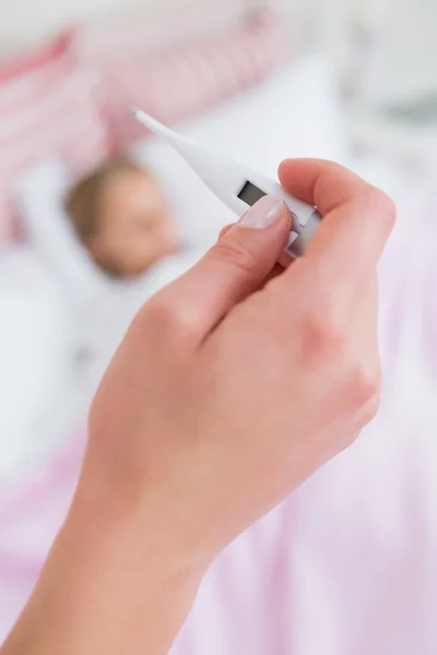 Mãe tomando a temperatura da filha doente — Fotografia de Stock