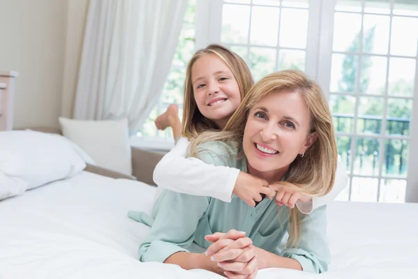 Mãe e filha felizes sorrindo para a câmera — Fotografia de Stock