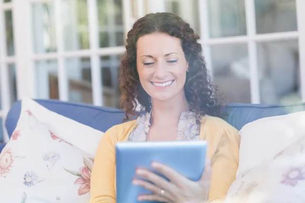 Brünette entspannt auf der Couch mit Tablet — Stockfoto