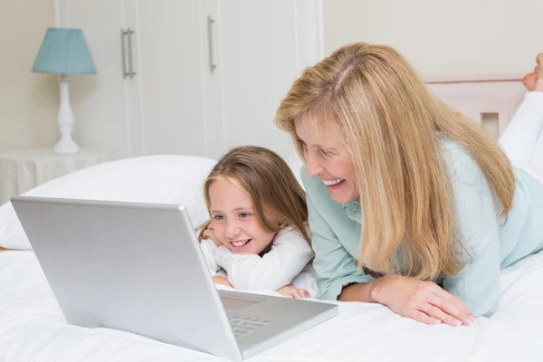 Mère heureuse et fille en utilisant un ordinateur portable — Photo