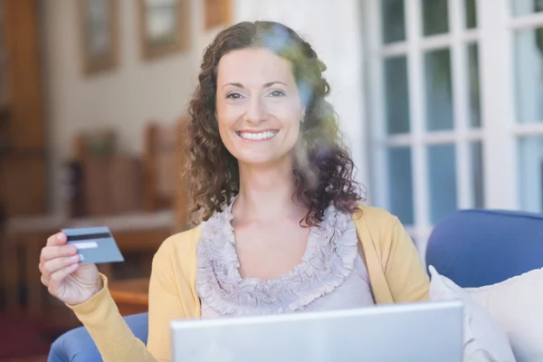 Morena relaxante no sofá com laptop — Fotografia de Stock