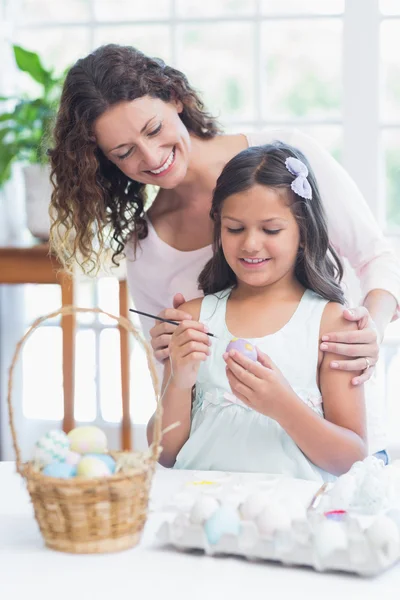 Happy mother and daughter painting easter eggs — Stock Photo, Image