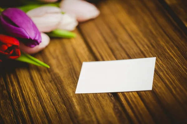 Manojo de tulipanes y tarjeta blanca — Foto de Stock