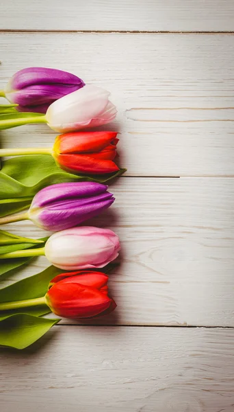 Tulipany na drewnianym stole — Zdjęcie stockowe