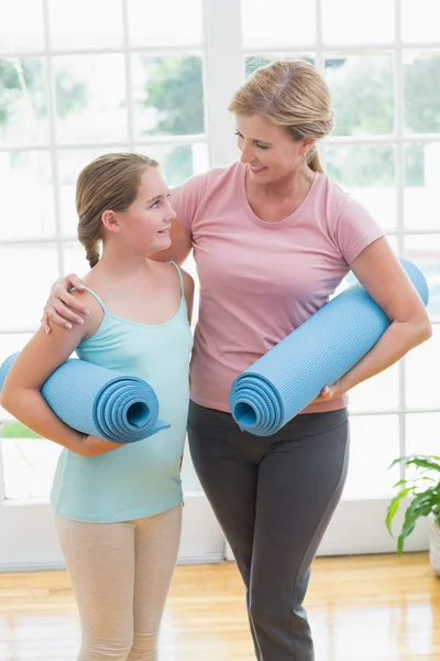 Madre e hija sosteniendo colchonetas de yoga — Foto de Stock