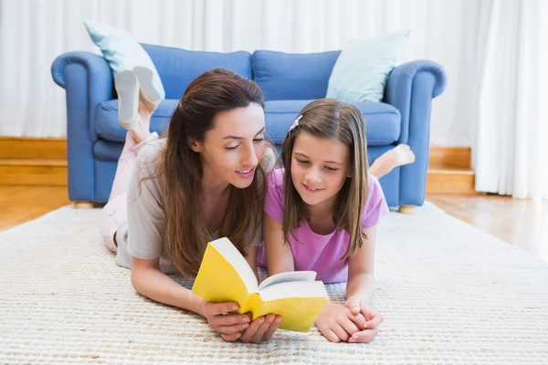 Moeder en dochter lezen op de verdieping — Stockfoto