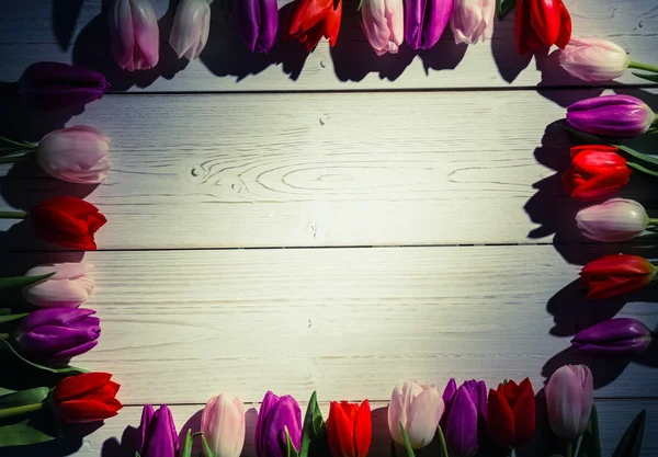 Tulipanes formando marco en mesa de madera —  Fotos de Stock