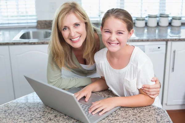 Happy mother and daughter using laptop together — Stock Photo, Image