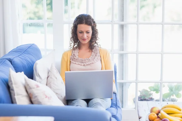 Morena relaxante no sofá com laptop — Fotografia de Stock