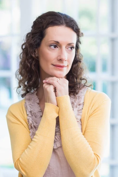 Thoughtful brunette standing hands together — Stock Photo, Image