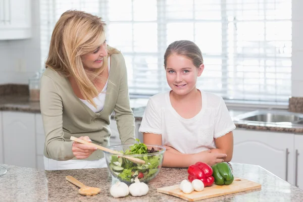 Happy mother and daughter preparing salad together — Stock Photo, Image