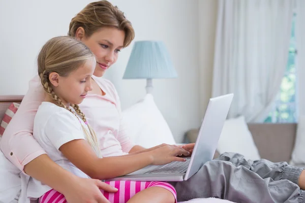 Mutter und Tochter benutzen Laptop im Bett — Stockfoto