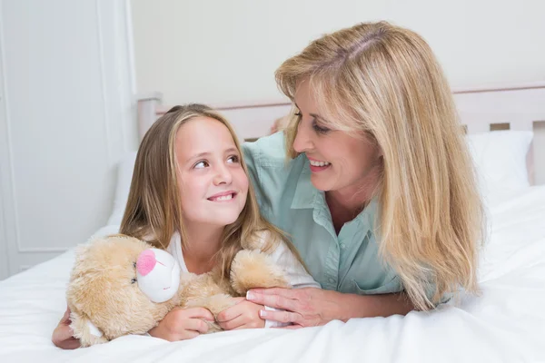 Glückliche Mutter und Tochter lächeln einander an — Stockfoto