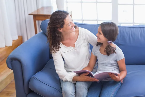 Happy mother and daughter reading book — Stock Photo, Image