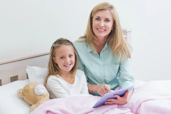 Madre e hija feliz usando tableta —  Fotos de Stock