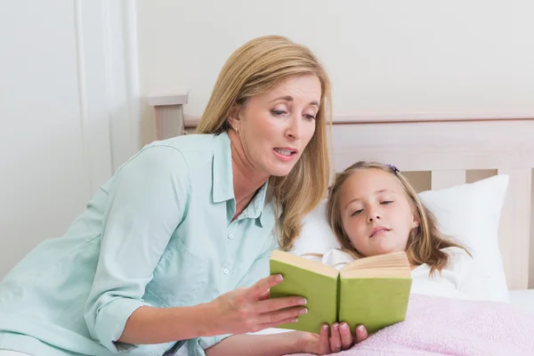 Feliz madre e hija leyendo un libro — Foto de Stock