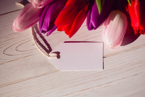 Tulipány a bílou kartu — Stock fotografie