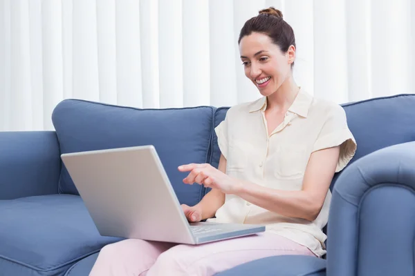 Casual brunette using laptop on couch — Stock Photo, Image