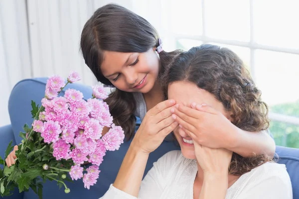 Uśmiechnięta dziewczyna oferuje kwiaty do matki — Zdjęcie stockowe
