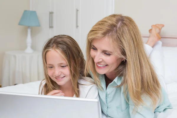 Happy mother and daughter using laptop — Stock Photo, Image