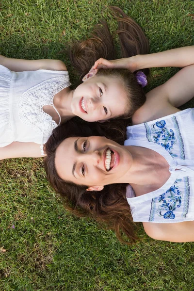 Moeder en dochter liggen op gras — Stockfoto