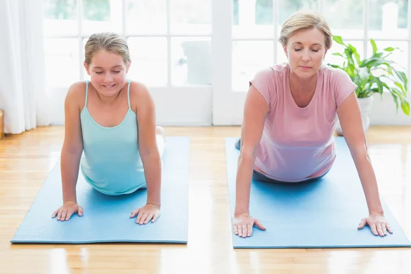 Mor og datter som driver med yoga – stockfoto