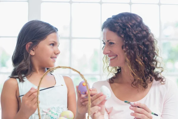 Happy mother and daughter painting easter eggs — Stock Photo, Image