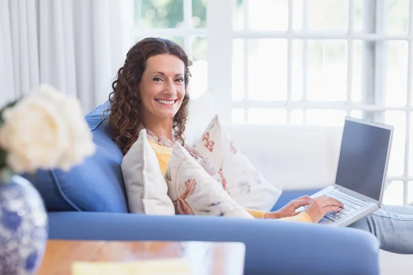 Brunette ontspannen op de Bank met laptop — Stockfoto